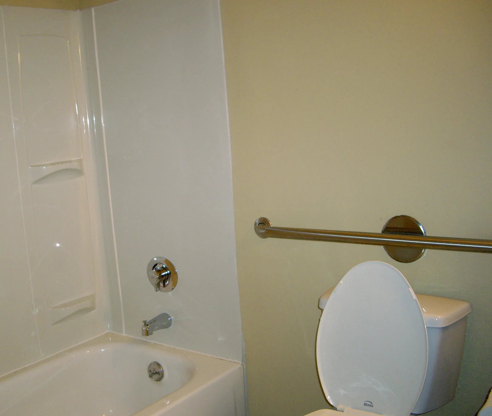 Bathroom with a toilet, shower and grab bar