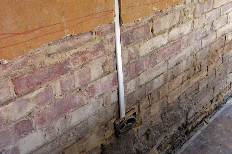 Lower wall with plaster removed during a rising-damp treatment